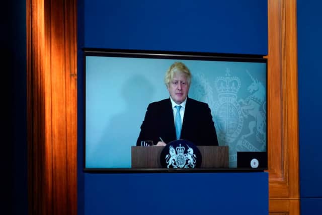 Britain’s Prime Minister, Boris Johnson attends a media briefing on coronavirus online via a screen from Chequers, the country house of the Prime Minister where he is self-isolating at Downing Street on July 19, 2021 in London, England. 