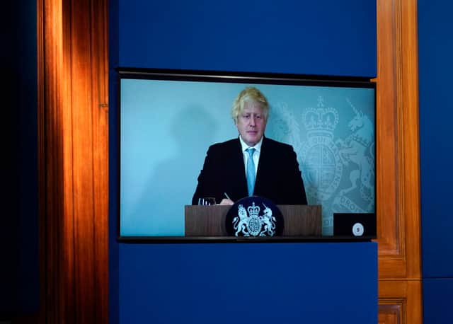 Britain’s Prime Minister, Boris Johnson attends a media briefing on coronavirus online via a screen from Chequers, the country house of the Prime Minister where he is self-isolating at Downing Street on July 19, 2021 in London, England.