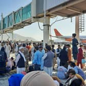 Afghans crowd at the tarmac of the Kabul airport on August 16, 2021, to flee the country as the Taliban were in control of Afghanistan