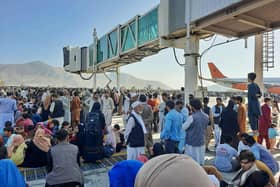 Afghans crowd at the tarmac of the Kabul airport on August 16, 2021, to flee the country as the Taliban were in control of Afghanistan