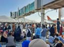 Afghans crowd at the tarmac of the Kabul airport on August 16, 2021, to flee the country as the Taliban were in control of Afghanistan