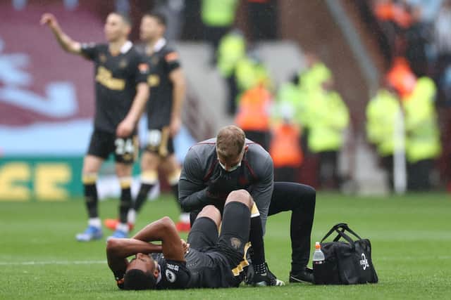 Isaac Hayden of Newcastle United receives medical treatment during the Premier League match between Aston Villa and Newcastle United at Villa Park on August 21, 2021 in Birmingham, England.
