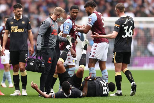 Jamaal Lascelles of Newcastle United is pushed over by Ezri Konsa and Tyrone Mings of Aston Villa during the Premier League match between Aston Villa and Newcastle United at Villa Park on August 21, 2021 in Birmingham, England. (Photo by Ryan Pierse/Getty Images)