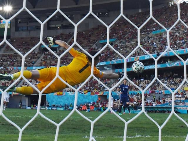 Slovakia’s goalkeeper Martin Dubravka dives to save a goal during the UEFA EURO 2020 Group E football match between Slovakia and Spain at La Cartuja Stadium in Seville on June 23, 2021. 