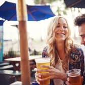 Couple enjoy a drink in a sunny beer garden. (Pic: Shutterstock)