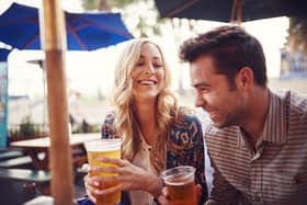 Couple enjoy a drink in a sunny beer garden. (Pic: Shutterstock)