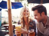 Couple enjoy a drink in a sunny beer garden. (Pic: Shutterstock)