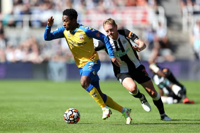 Kyle Walker-Peters of Southampton runs with the ball away from Sean Longstaff of Newcastle United during the Premier League match between Newcastle United  and  Southampton at St. James Park on August 28, 2021 in Newcastle upon Tyne, England. 