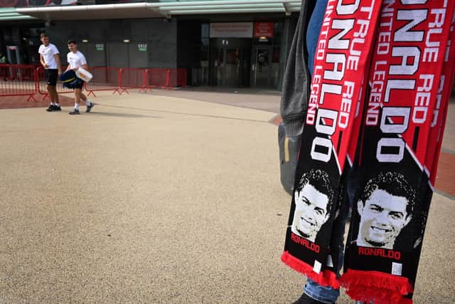A vendor sells scarves of Manchester United’s new signing Cristiano Ronaldo at Old Trafford stadium in Manchester, northwest England on September 6, 2021. 