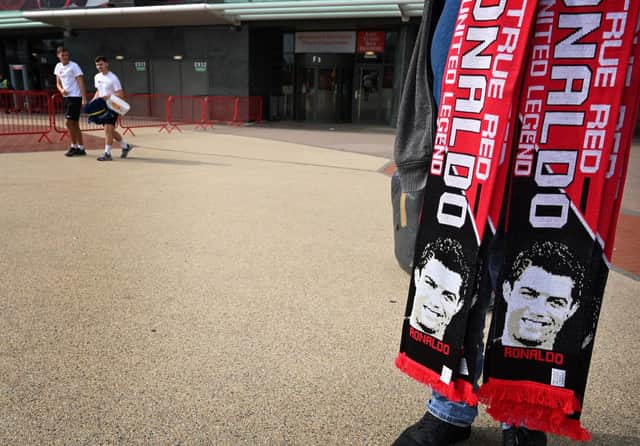 A vendor sells scarves of Manchester United’s new signing Cristiano Ronaldo at Old Trafford stadium in Manchester, northwest England on September 6, 2021. 