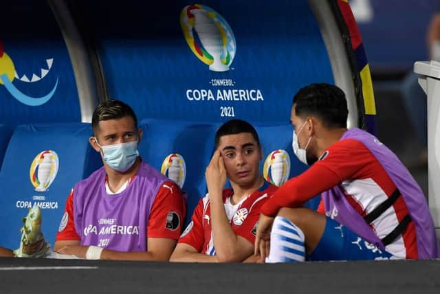 Paraguay’s Miguel Almiron (C) speaks with teammates after leaving the field due to an injury during the Conmebol Copa America 2021 football tournament group phase match between Uruguay and Paraguay at the Nilton Santos Stadium in Rio de Janeiro, Brazil, on June 28, 2021.