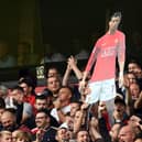A cardboard cut out of new signing Cristiano Ronaldo is held by Manchester United supporters during the English Premier League football match between Wolverhampton Wanderers and Manchester United at the Molineux stadium in Wolverhampton, central England on August 29, 2021.  