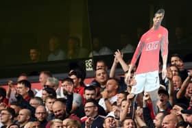 A cardboard cut out of new signing Cristiano Ronaldo is held by Manchester United supporters during the English Premier League football match between Wolverhampton Wanderers and Manchester United at the Molineux stadium in Wolverhampton, central England on August 29, 2021.  