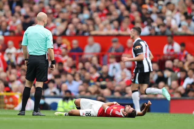 Bruno Fernandes of Manchester United lies on the floor as he looks to be injured during the Premier League match between Manchester United and Newcastle United at Old Trafford on September 11, 2021 in Manchester, England. 