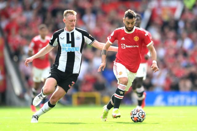 Bruno Fernandes of Manchester United battles for possession with Sean Longstaff of Newcastle United during the Premier League match between Manchester United and Newcastle United at Old Trafford on September 11, 2021 in Manchester, England.