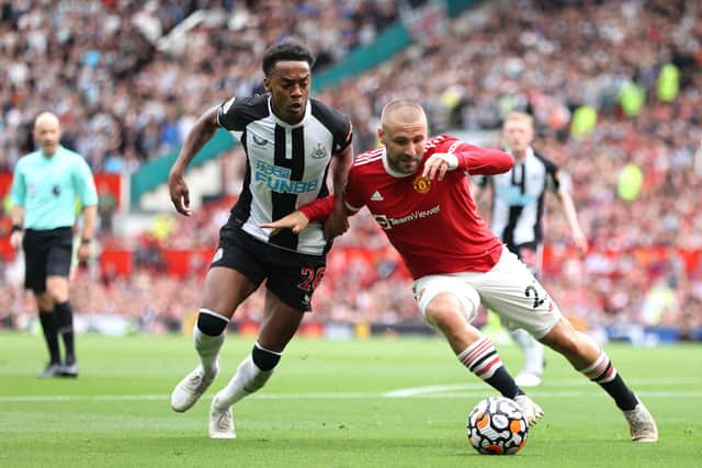 Luke Shaw of Manchester United battles for possession with Joe Willock of Newcastle United during the Premier League match between Manchester United and Newcastle United at Old Trafford on September 11, 2021 in Manchester, England.