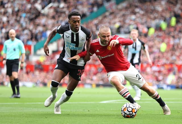 Luke Shaw of Manchester United battles for possession with Joe Willock of Newcastle United during the Premier League match between Manchester United and Newcastle United at Old Trafford on September 11, 2021 in Manchester, England.
