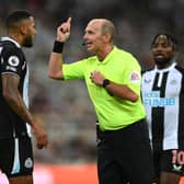 Referee Mike Dean has words with Jamaal Lascelles during the Premier League match between Newcastle United  and  Leeds United at St. James Park on September 17, 2021 in Newcastle upon Tyne, England. 
