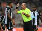 Referee Mike Dean has words with Jamaal Lascelles during the Premier League match between Newcastle United  and  Leeds United at St. James Park on September 17, 2021 in Newcastle upon Tyne, England. 