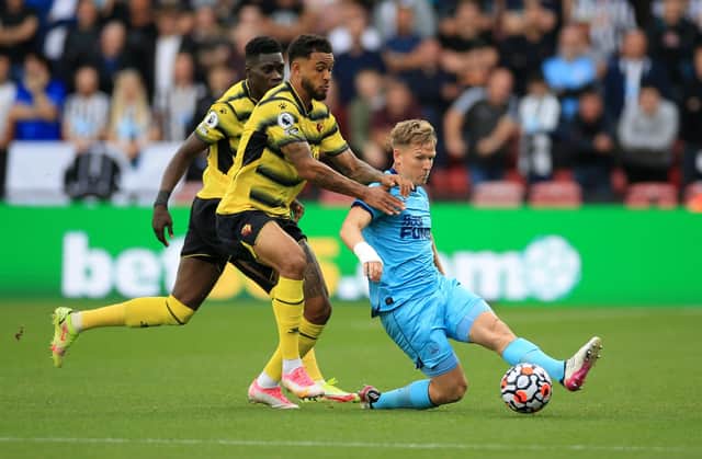 Joshua King of Watford FC with Matt Ritchie of Newcastle United  during the Premier League match between Watford and Newcastle United at Vicarage Road on September 25, 2021 in Watford, England. 