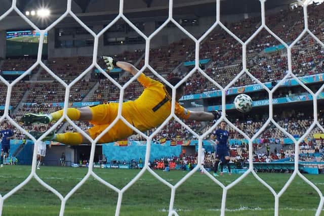 Slovakia’s goalkeeper Martin Dubravka dives to save a goal during the UEFA EURO 2020 Group E football match between Slovakia and Spain at La Cartuja Stadium in Seville on June 23, 2021. 