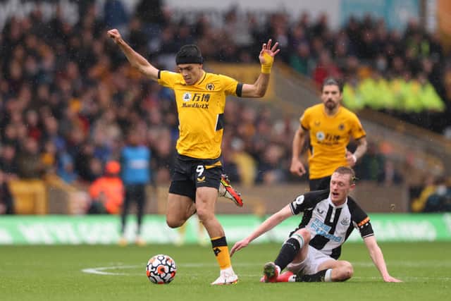Raul Jimenez of Wolverhampton Wanderers is tackled by Sean Longstaff of Newcastle United during the Premier League match between Wolverhampton Wanderers and Newcastle United at Molineux on October 02, 2021 in Wolverhampton, England.