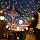 A shopper wearing a face mask or covering due to the COVID-19 pandemic, carries shopping bags through central Newcastle-upon-Tyne, in north-east England on December 19, 2020, on the last Saturday before Christmas. 