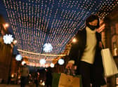 A shopper wearing a face mask or covering due to the COVID-19 pandemic, carries shopping bags through central Newcastle-upon-Tyne, in north-east England on December 19, 2020, on the last Saturday before Christmas. 