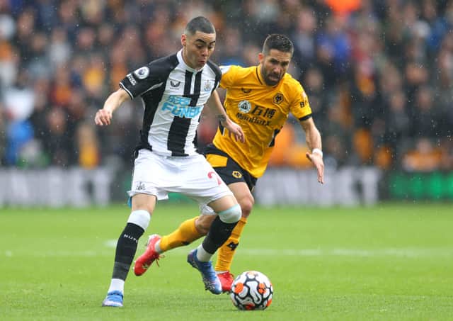 Miguel Almiron of Newcastle United battles for possession with Joao Moutinho of Wolverhampton Wanderers during the Premier League match between Wolverhampton Wanderers and Newcastle United at Molineux on October 02, 2021 in Wolverhampton, England.