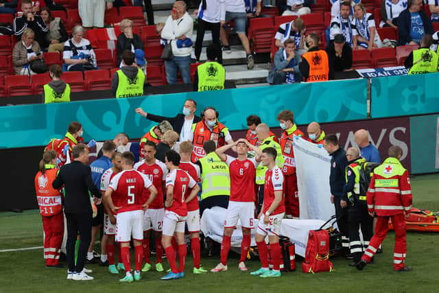 Den,ark players shelter Christian Eriksen as he receives treatment (Image: Getty Images)