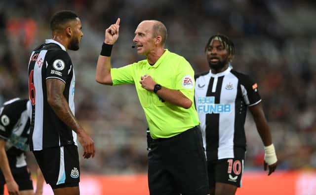 Referee Mike Dean has words with Jamaal Lascelles during the Premier League match between Newcastle United  and  Leeds United at St. James Park on September 17, 2021 in Newcastle upon Tyne, England.