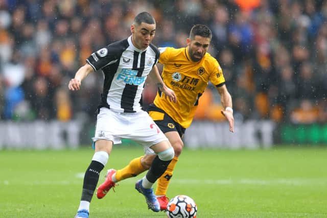 Miguel Almiron of Newcastle United battles for possession with Joao Moutinho of Wolverhampton Wanderers during the Premier League match between Wolverhampton Wanderers and Newcastle United at Molineux on October 02, 2021 in Wolverhampton, England.