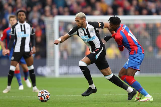 Joelinton of Newcastle United is challenged by Wilfried Zaha of Crystal Palace during the Premier League match between Crystal Palace and Newcastle United at Selhurst Park on October 23, 2021 in London, England. 