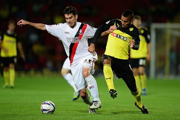 Lewis McGugan of Watford battles with Richard Hughes of Bournemouth during the Capital One Cup second round match between Watford and AFC Bournemouth at Vicarage Road on August 28, 2013 in Watford, England.  (Photo by Jamie McDonald/Getty Images)