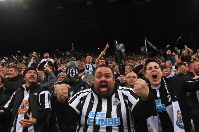 Newcastle fans in the Gallowgate End celebrate the opening goal scored by Callum Wilson during the Premier League match between Newcastle United and Tottenham Hotspur at St. James Park on October 17, 2021 in Newcastle upon Tyne, England. 