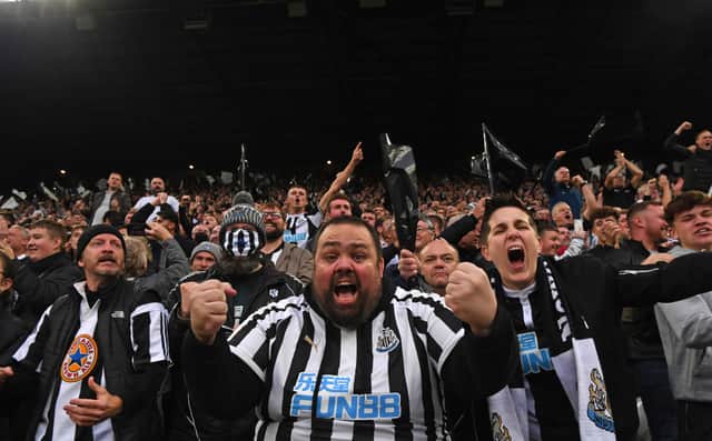 Newcastle fans in the Gallowgate End celebrate the opening goal scored by Callum Wilson during the Premier League match between Newcastle United and Tottenham Hotspur at St. James Park on October 17, 2021 in Newcastle upon Tyne, England. 