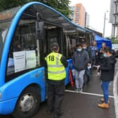 People queue to receive a dose of the Pfizer/BioNTech covid-19 vaccine at a mobile vaccination centre set up in a bus parked outside Premier League club Newcastle United’s St James’s Park football stadium in Newcastle, north east England on August 15, 2021. - The UK opens Covid-19 vaccination appointments to 16-19 year old, hoping that all in this age group are offered a dose of the vaccine by August 23.