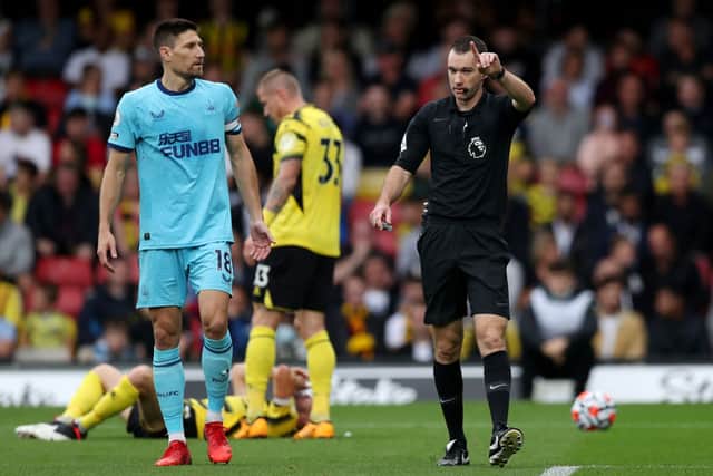 Jarred Gillett, the match referee interacts with Federico Fernandez of Newcastle United   during the Premier League match between Watford and Newcastle United at Vicarage Road on September 25, 2021 in Watford, England. 