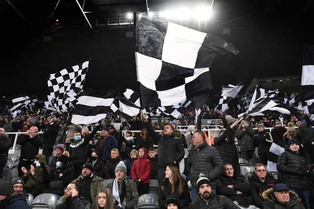 Newcastle fans fly their flags in the Gallowgate end in the dying moments of the game during the Premier League match between Newcastle United  and  Manchester City at St. James Park on December 19, 2021 in Newcastle upon Tyne, England. 