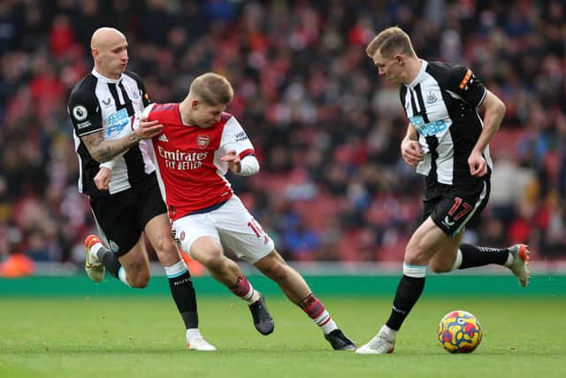 Emile Smith Rowe of Arsenal battles for possession with Emil Krafth and Jonjo Shelvey of Newcastle United during the Premier League match between Arsenal and Newcastle United at Emirates Stadium on November 27, 2021 in London, England.