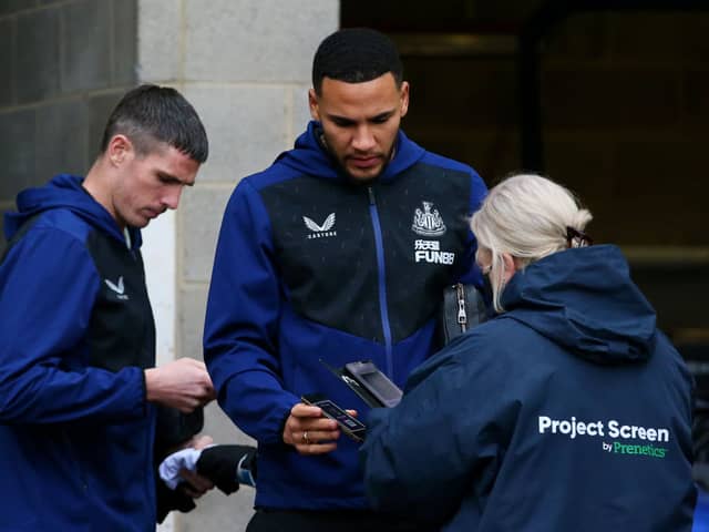 Ciaran Clark and Jamaal Lascelles of Newcastle United have their Covid-19 passes scanned as they arrive at the stadium prior to the Premier League match between Newcastle United and Manchester City at St. James Park on December 19, 2021 in Newcastle upon Tyne, England.