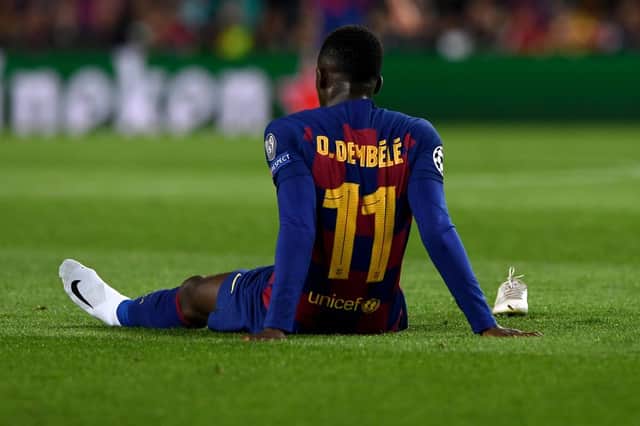 Barcelona’s French forward Ousmane Dembele sits on the ground after an injury during the UEFA Champions League Group F football match between FC Barcelona and Borussia Dortmund at the Camp Nou stadium in Barcelona, on November 27, 2019. 