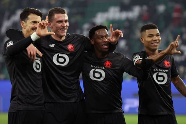 (L-R) Lille’s Portuguese defender Jose Fonte, Lille’s Dutch defender Sven Botman, Lille’s Canadian forward Jonathan David and Lille’s Mozambican defender Reinildo Mandava celebrate scoring during the UEFA Champions League group G football match VfL Wolfsburg v Lille LOSC in Wolfsburg, northern Germany on December 8, 2021. 