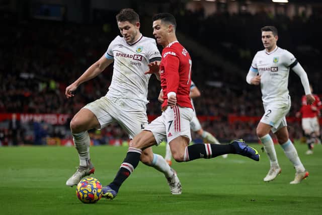 Cristiano Ronaldo of Manchester United is challenged by James Tarkowski of Burnley during the Premier League match between Manchester United  and  Burnley at Old Trafford on December 30, 2021 in Manchester, England. 