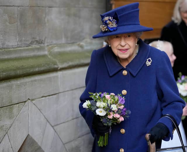 Queen Elizabeth II receives flowers as she leaves after attending a service of Thanksgiving to mark the centenary of The Royal British Legion at Westminster Abbey on October 12, 2021 in London, England.