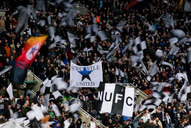  Newcastle United fans wave flags and show their support during the Premier League match between Newcastle United and Everton at St. James Park
