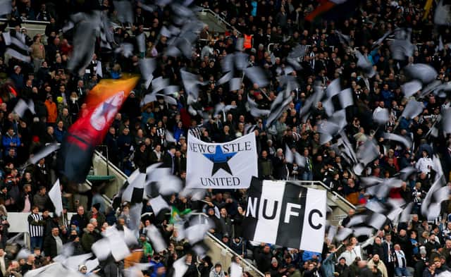  Newcastle United fans wave flags and show their support during the Premier League match between Newcastle United and Everton at St. James Park