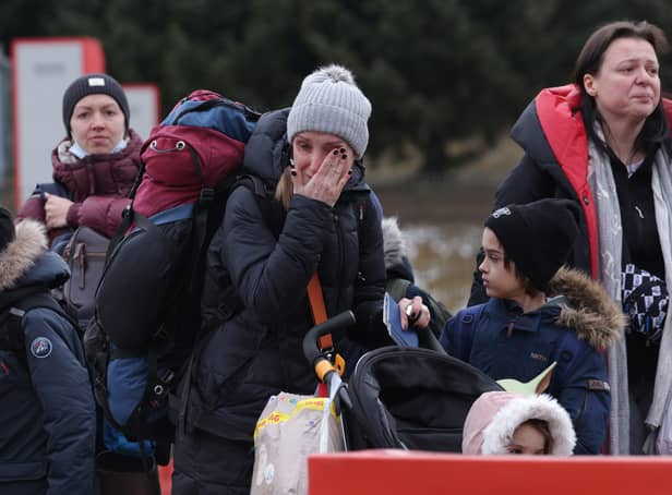 <p>KORCZOWA, POLAND - MARCH 02: A distraught mother wipes tears as she and her children fleeing war-torn Ukraine wait to cross into Poland at the Korczowa crossing on March 02, 2022 near Korczowa, Poland. Women and children arrived at the crossing throughout the day, some tearful as many have left their fathers, husbands and grown sons behind. Ukraine authorities are forbidding men aged between 18 and 60 from leaving and calling on them to fight. More than 400, 000 people have crossed the border into Poland from Ukraine in the first week since Russia’s invasion. Meanwhile fighting is raging between the invading Russian military and Ukrainian armed forces across Ukraine. (Photo by Sean Gallup/Getty Images)</p>