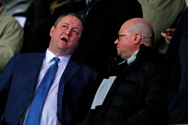 Newcastle United’s English owner Mike Ashley (L) chats with director Lee Charnley (R) in the crowd ahead of the FA Cup fourth round replay football match between Oxford United and Newcastle United at the Kassam Stadium in Oxford, west of London, on February 4, 2020. 