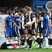 LONDON, ENGLAND - MARCH 13: Players of Chelsea and Newcastle United interact as Bruno Guimaraes of Newcastle United is injured during the Premier League match between Chelsea and Newcastle United at Stamford Bridge on March 13, 2022 in London, England. (Photo by Clive Mason/Getty Images)